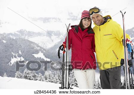 Stock Photograph - Middle Aged Couple On Ski Holiday In Mountains. Fotosearch