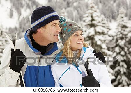 Stock Photography - Middle Aged Couple On Ski Holiday In Mountains. Fotosearch