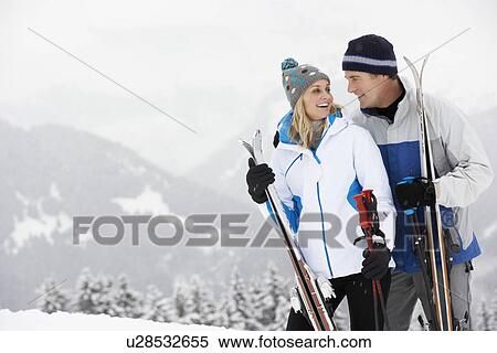 Stock Photography - Middle Aged Couple On Ski Holiday In Mountains. Fotosearch