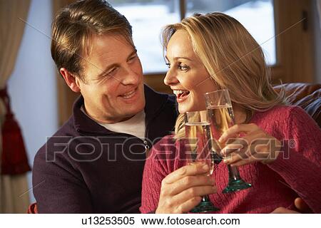 Middle Aged Couple Sitting On Sofa With Glasses Of Champagne View Large Photo Image Stock Photography - Middle Aged Couple Sitting On Sofa With Glasses Of Champagne. Fotosearch