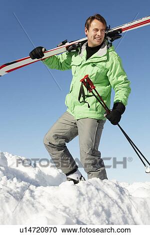Stock Image - Middle Aged Man On Ski Holiday In Mountains. Fotosearch