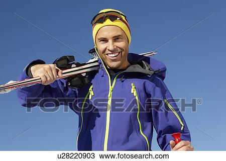 Stock Image - Middle Aged Man On Ski Holiday In Mountains. Fotosearch
