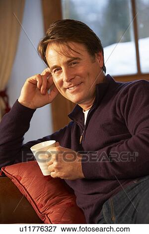 Middle Aged Man Relaxing With Hot Drink On Sofa View Large Photo Image Stock Photo - Middle Aged Man Relaxing With Hot Drink On Sofa. Fotosearch