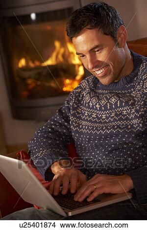Middle Aged Man Using Laptop Computer By Cosy Log Fire View Large Photo Image Picture - Middle Aged Man Using Laptop Computer By Cosy Log Fire. Fotosearch