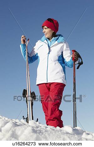 Stock Image - Middle Aged Woman On Ski Holiday In Mountains. Fotosearch