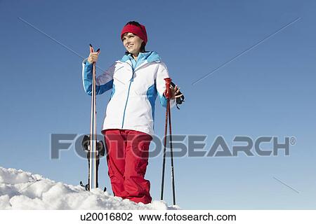 Stock Image - Middle Aged Woman On Ski Holiday In Mountains. Fotosearch