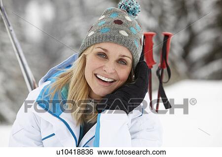 Stock Photograph - Middle Aged Woman On Ski Holiday In Mountains. Fotosearch