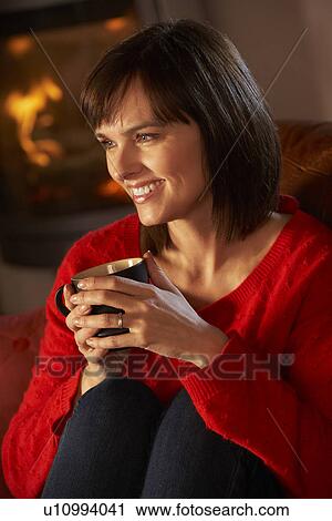 Middle Aged Woman Relaxing With Hot Drink By Cosy Log Fire View Large Photo Image Stock Image - Middle Aged Woman Relaxing With Hot Drink By Cosy Log Fire. Fotosearch