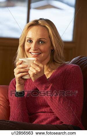 Middle Aged Woman Relaxing With Hot Drink On Sofa Watching TV View Large Photo Image Stock Image - Middle Aged Woman Relaxing With Hot Drink On Sofa Watching TV. Fotosearch