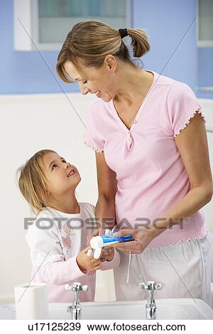 Mother and daughter cleaning teeth in bathroom View Large Photo Image Stock Photo - Mother and daughter cleaning teeth in bathroom. Fotosearch
