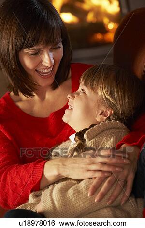 Mother And Daughter Relaxing On Sofa By Cosy Log Fire View Large Photo Image Stock Photograph - Mother And Daughter Relaxing On Sofa By Cosy Log Fire. Fotosearch