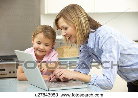 Mother and daughter using laptop in domestic kitchen View Large Photo Image Stock Image - Mother and daughter using laptop in domestic kitchen. Fotosearch