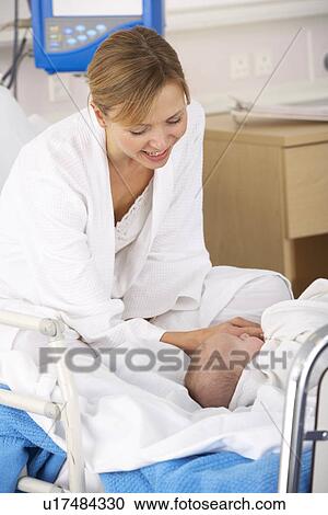 Stock Image - Mother in hospital with newborn baby. Fotosearch