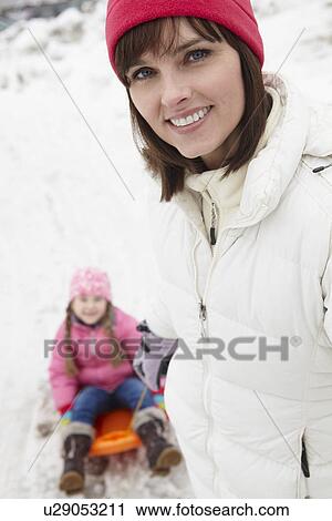 Mother Pulling Daughter On Sledge Along Snowy Street In Ski Resort View Large Photo Image Stock Image - Mother Pulling Daughter On Sledge Along Snowy Street In Ski Resort. Fotosearch