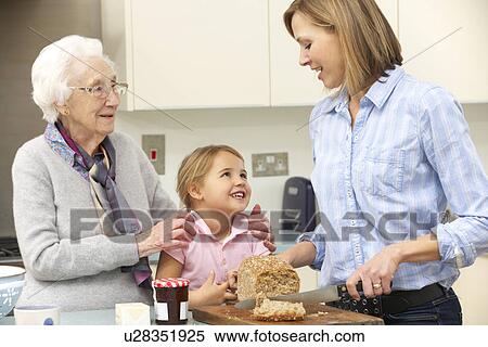 Multi-generation family preparing food in kitchen View Large Photo Image Stock Photography - Multi-generation family preparing food in kitchen. Fotosearch