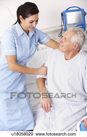 Nurse helping male patient in UK Accident and Emergency View Large Photo Image Stock Photo - Nurse helping male patient in UK Accident and Emergency. Fotosearch