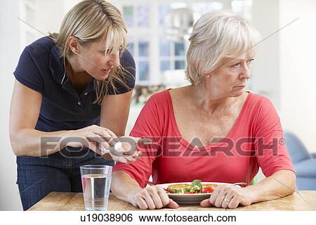 Stock Photograph - Older woman refusing medication at home. Fotosearch