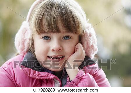 Stock Photo - Outdoor Portrait Of Young Girl Wearing Winter Clothes And Earmuffs. Fotosearch