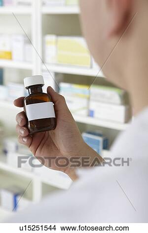 Pharmacist holding prescription pill bottle View Large Photo Image Picture - Pharmacist holding prescription pill bottle. Fotosearch