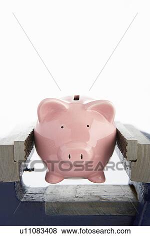 Stock Photo - Piggybank in a vice. Fotosearch