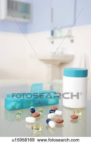 Stock Photo - Pills and organiser in bathroom. Fotosearch