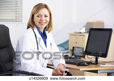 Stock Photo - Portrait American doctor sitting at desk. Fotosearch