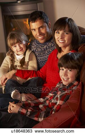 Portrait Of Family Relaxing On Sofa By Cosy Log Fire View Large Photo Image Stock Image - Portrait Of Family Relaxing On Sofa By Cosy Log Fire. Fotosearch