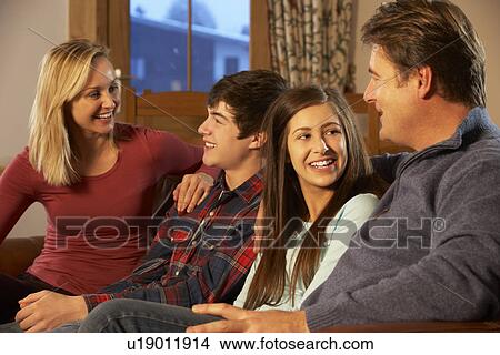 Picture - Portrait Of Family Relaxing On Sofa Together. Fotosearch