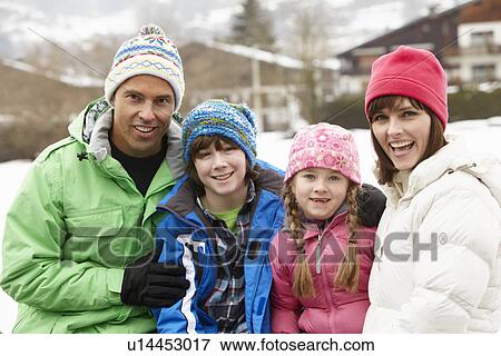 Stock Photo - Portrait Of Family Wearing Winter Clothes In Snowy Landscape. Fotosearch