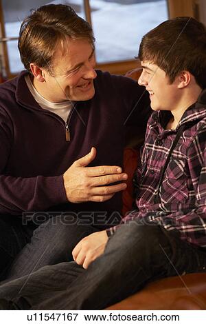 Portrait Of Father And Son Relaxing On Sofa Together View Large Photo Image Stock Photo - Portrait Of Father And Son Relaxing On Sofa Together. Fotosearch