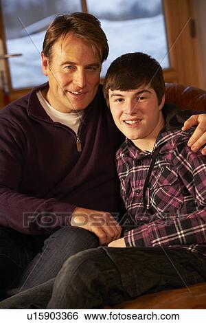 Portrait Of Father And Son Relaxing On Sofa Together View Large Photo Image Stock Photograph - Portrait Of Father And Son Relaxing On Sofa Together. Fotosearch