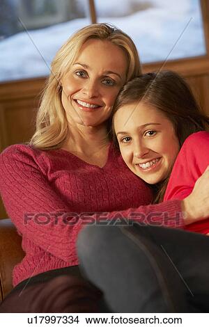 Picture - Portrait Of Mother And Daughter Relaxing On Sofa Together. Fotosearch