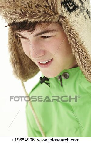 Stock Photograph - Portrait Of Teenage Boy In Snow Wearing Fur Hat. Fotosearch