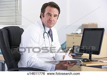 Portrait UK doctor sitting at desk View Large Photo Image Stock Photograph - Portrait UK doctor sitting at desk. Fotosearch