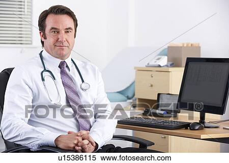 Stock Photography - Portrait UK doctor sitting at desk. Fotosearch