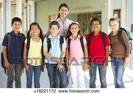 Stock Image - Pre teen schoolchildren with teacher. Fotosearch