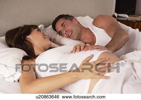 Pregnant woman and husband in bed View Large Photo Image Stock Photograph - Pregnant woman and husband in bed. Fotosearch