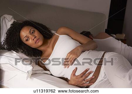 Stock Image - Pregnant woman unable to sleep. Fotosearch