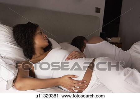 Stock Image - Pregnant woman unable to sleep. Fotosearch