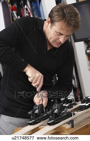 Sales Assistant Adjusting Fittings On Skis In Hire Shop View Large Photo Image Stock Photo - Sales Assistant Adjusting Fittings On Skis In Hire Shop. Fotosearch