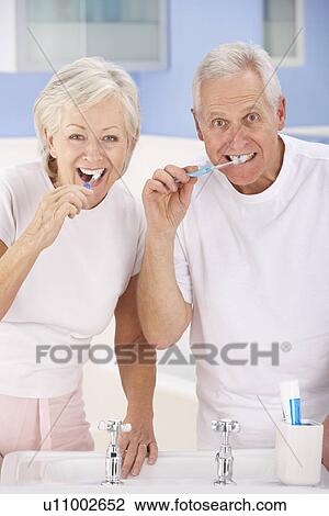 Stock Image - Senior couple brushing teeth. Fotosearch