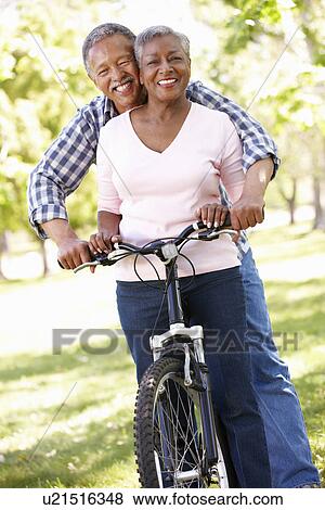 Stock Photo - Senior couple cycling in park. Fotosearch