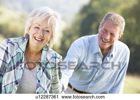 Stock Image - Senior couple on country walk. Fotosearch