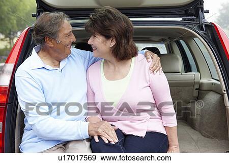 Stock Photo - Senior Hispanic couple outdoors with car. Fotosearch