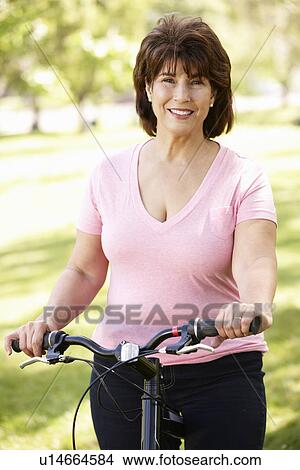 Picture - Senior Hispanic woman with bike. Fotosearch