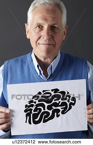 Stock Image - Senior man holding ink drawing of brain. Fotosearch