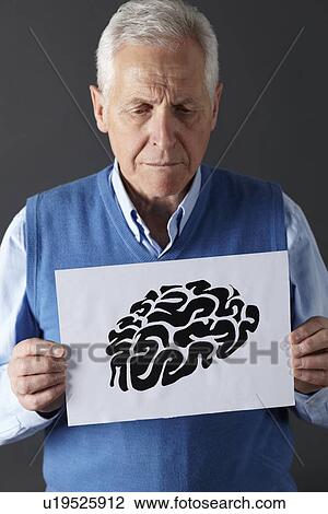 Stock Image - Senior man holding ink drawing of brain. Fotosearch