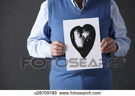 Senior man holding ink drawing of heart View Large Photo Image Stock Photo - Senior man holding ink drawing of heart. Fotosearch