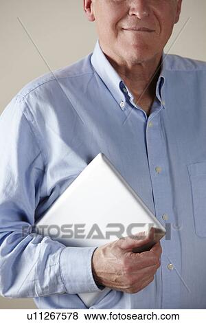 Stock Photo - Senior man holding tablet. Fotosearch