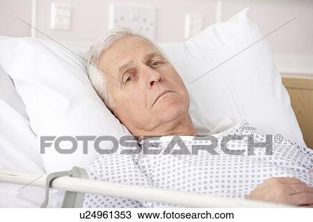 Stock Image - Senior man ill in hospital bed. Fotosearch